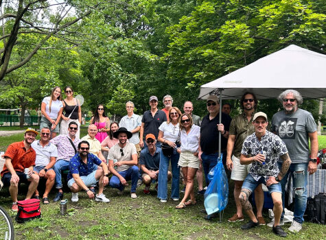 The Strigo team is gathered in a park during the summer for a company picnic.