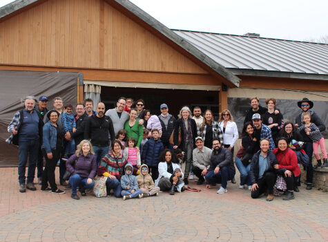 Les membres de l'équipe Strigo et leurs familles réunies devant une cabane à sucre au Québec.