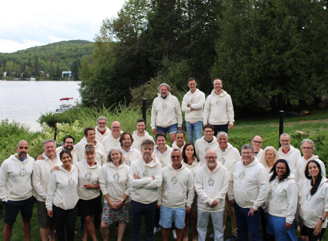 L'équipe Strigo est réunie dehors à Mont-Tremblant. Tout le monde porte des cotons ouatés blancs aux couleurs de la compagnie.